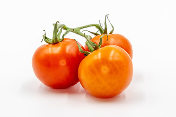 Three red tomatoes with branch