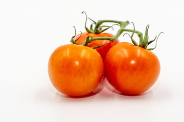 Three red tomatoes with branch