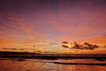 the beauty of Jimbaran beach in Bali Indonesia at dusk with the sun disappearing