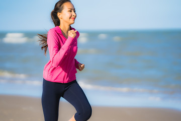 Portrait beautiful young asian woman running or exercise on the tropica nature landscape of beach