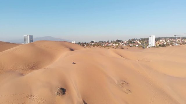 Drone aerial shot of dunes and the city and buildings on the back, sunny day, blue sky.
Concon, Valparaiso, Chile.
4K h264 30fps