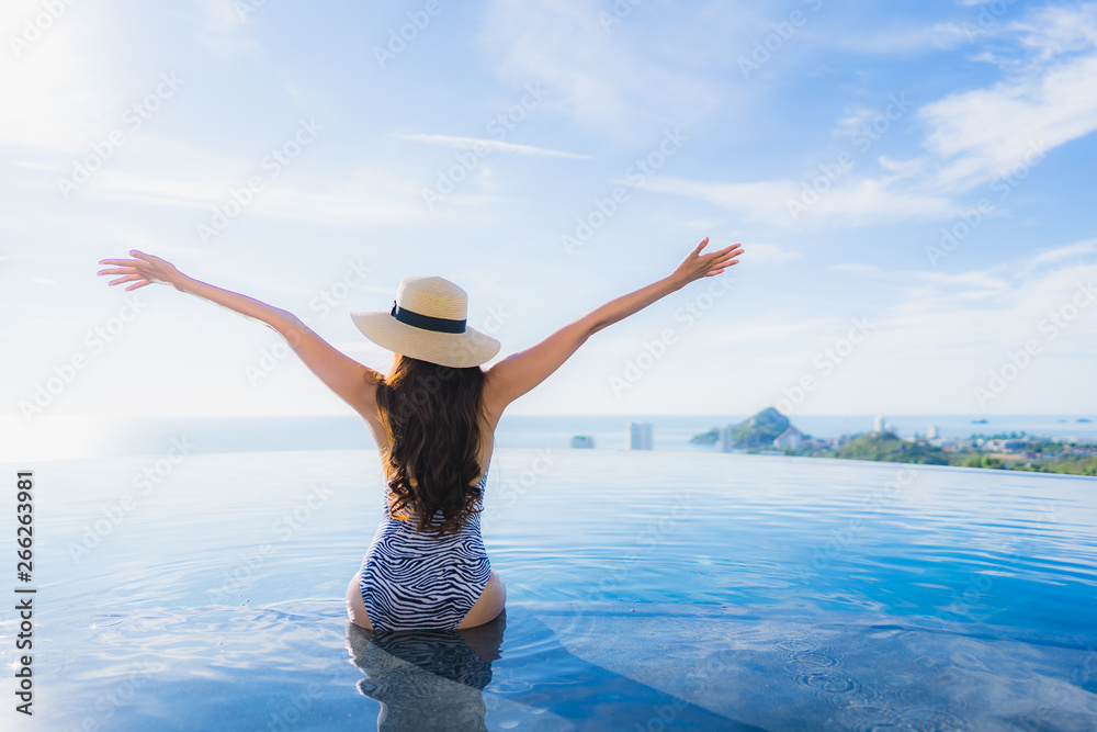 Wall mural portrait beautiful young asian woman smile happy relax around swimming pool in hotel resort for leis