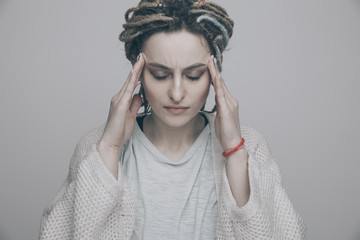 Woman with headache isolated over the grey studio