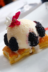 Vanilla ice cream with puff pastry and blackberry accompanied by strawberries and cherry.