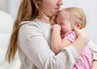 Mom calming her crying baby girl