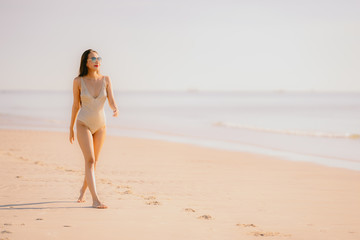 Fototapeta na wymiar Portrait beautiful young asian woman smile happy walk on the tropical outdoor nature beach sea