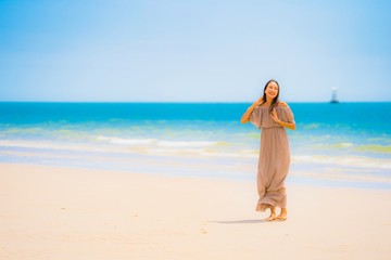 Fototapeta na wymiar Portrait beautiful young asian woman smile happy walk on the tropical outdoor nature beach sea