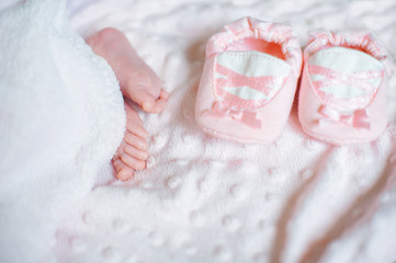 Fototapeta na wymiar Bare feet of a cute newborn baby in warm white blanket. Childhood. Small bare feet of a little baby girl. Sleeping newborn child