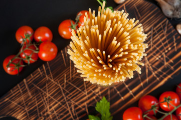 Uncooked pasta and cherry tomatoes, top view.