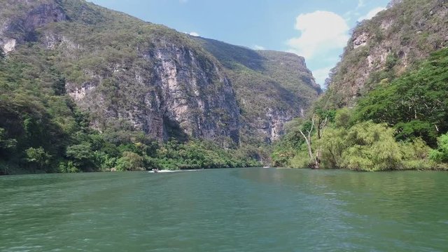 Boat sailing in the Grijalva river passing another boat just before the entrance to the Sumidero Canyon , Chiapas Mexico