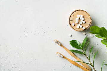 Zero waste and minimalism concept. Wooden ecological toothbrushes and toothpaste tablet on white background
