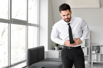 Businessman suffering from stomachache in office