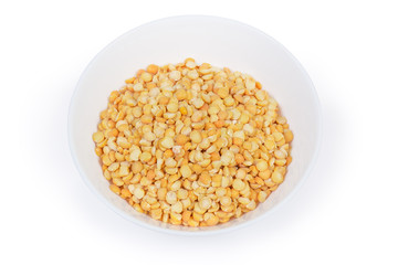 Yellow split peas in bowl on a white background