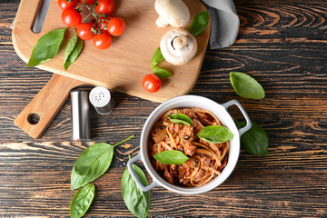 Pot with tasty boiled pasta on wooden table