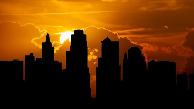 Kansas City skyline at Sunset with Red Sun, Clouds and Skyscrapers in Silhouette, Missouri, USA