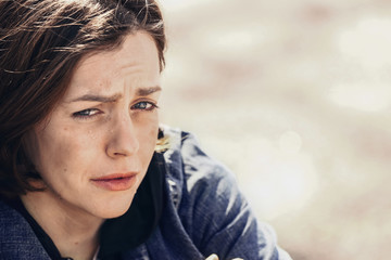 Portrait of sad homeless woman outdoors