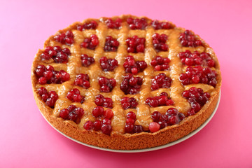 Tasty cranberry pie on color background