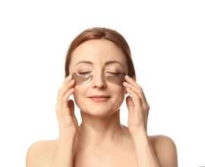 Mature woman with under-eye patches on white background