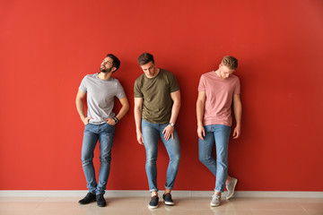 Fashionable young men near color wall