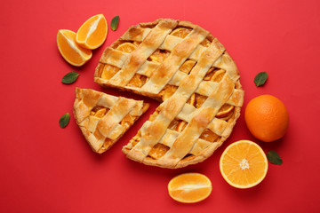 Tasty orange pie on color background