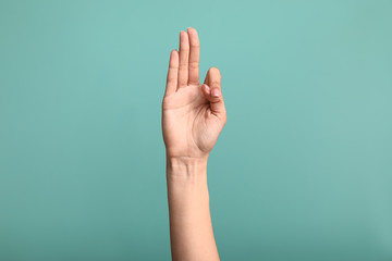 Female hand showing letter F on color background