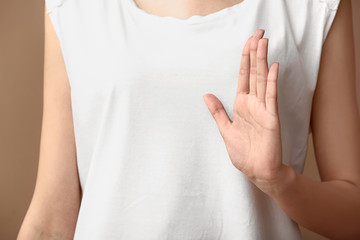 Woman showing gesture on color background, closeup