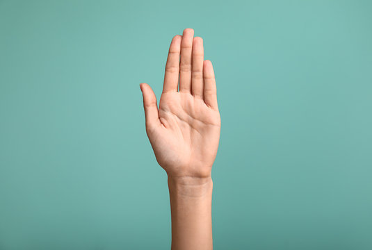 Gesturing female hand on color background