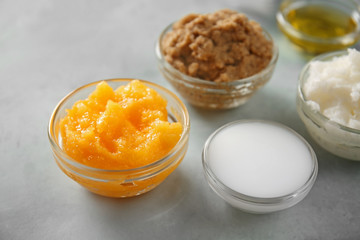 Bowls with different body scrubs on table
