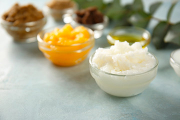 Bowls with different body scrubs on table