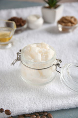 Jar with coconut body scrub on table