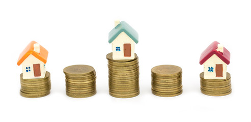 Mini house on stack of coins, Concept of Investment property, Investment risk and uncertainty in the real estate housing market. isolated on white background.