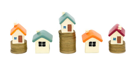 Mortgage concept by money house from the coins isolated on white background. Coin stack growing...