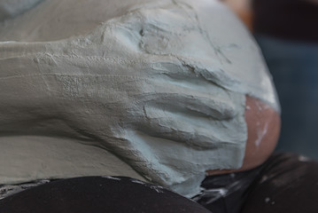 Someone puts plaster on the belly of a expectant young mother to get a plaster cast from the baby's...
