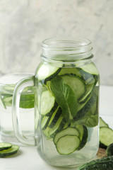 water with cucumber. Refreshing diet water with cucumber in a glass cup on a light background. detox drink concept. summer refreshing drink.
