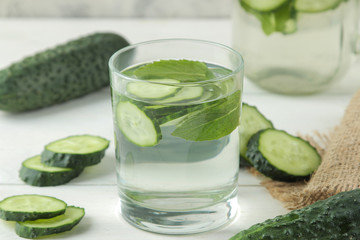 water with cucumber. Refreshing diet water with cucumber in a glass cup on a light background. detox drink concept. summer refreshing drink.