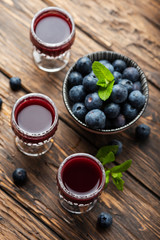 Sweet blueberry liqueur on the wooden table
