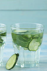 water with cucumber. Refreshing diet water with cucumber and mint in a glass beaker against a blue background. detox drink concept. summer refreshing drink.