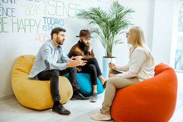 Homosexual couple during the psychological counseling with female psychologist in the modern office