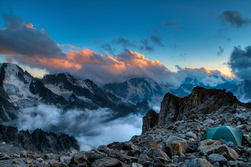 Fantastic morning landscape of rocky mountains at sunrise. Dramatic clouds in burning sky, morning light.