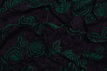 Creative dark fabric with green and violet patterns with textile texture background
