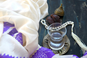 Iftar. Traditional food set to start evening meal during Ramadan fasting. Hot water in oriental glass, date fruits  on a wooden table.