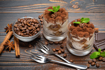 two portions Classic tiramisu dessert in a glass on wooden background