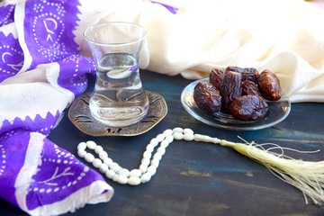 Iftar. Traditional food set to start evening meal during Ramadan fasting. Hot water in oriental glass, date fruits  on a wooden table.