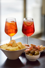 Italian aperitives/aperitif: glass of cocktail (sparkling wine with Aperol) and appetizer platter...