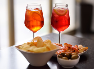 Italian aperitives/aperitif: glass of cocktail (sparkling wine with Aperol) and appetizer platter...