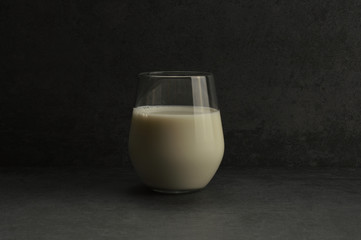 A glass of milk on the gray rustic stone background