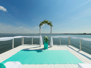 Place for wedding ceremony. Pier on bank of lake, Wedding arch
