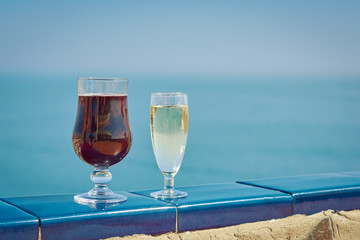 Flutes of wine are standing on the table against wonderful ocean background.