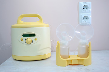 At the room for breast milk taking. Milk pump placed on a table