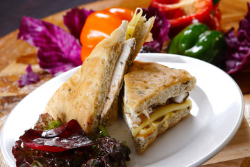 Traditional bread sandwich with serrano ham, cheese and spinach leaves.